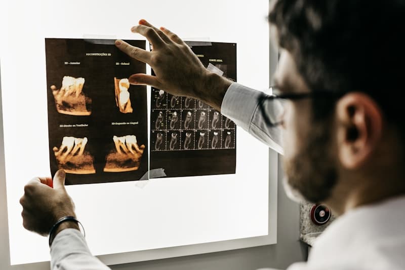 Dentista analisando reconstruções de tomografia 3D de um dente em um negatoscópio