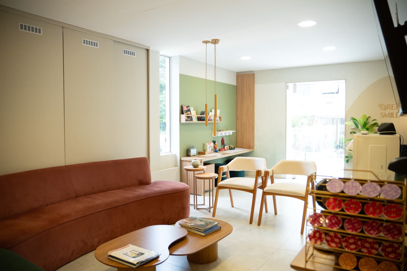 Sala de espera da Dream Smile com sofá, mesa de centro e um cantinho de leitura